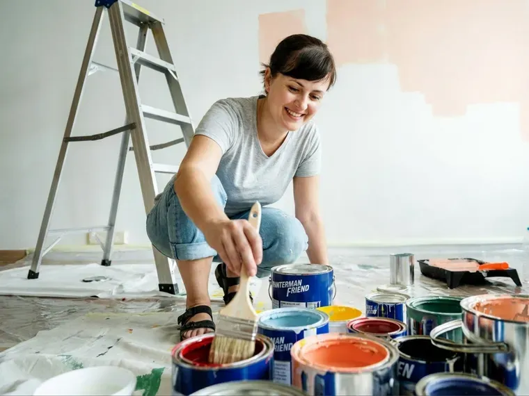 A decorator mixing paint before starting a wall
