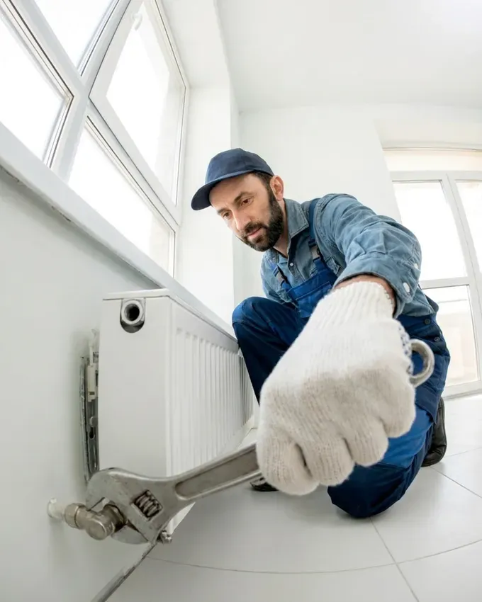 A plumber fitting a radiator